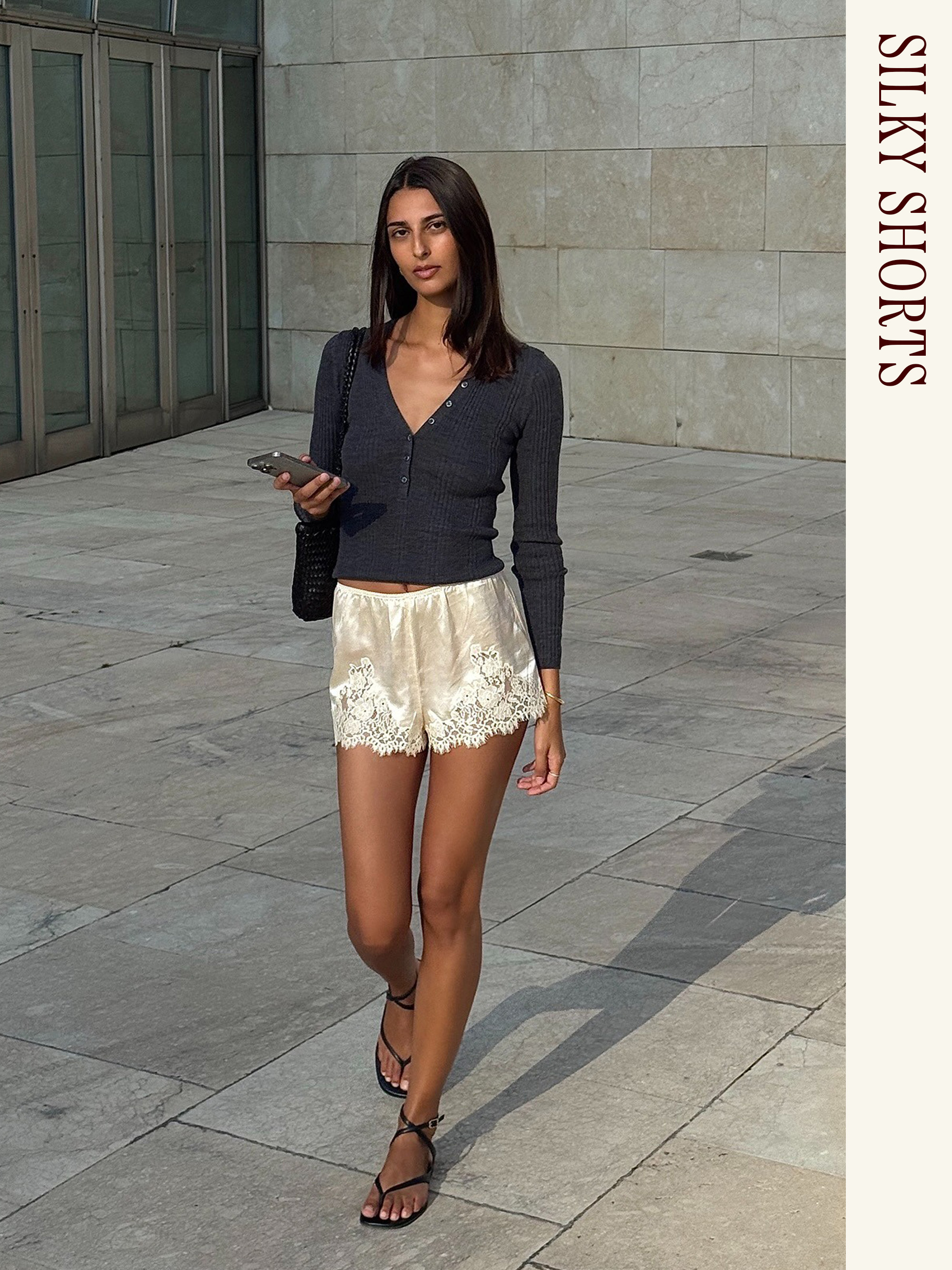 Influencer wearing a black cardigan and Doen satin shorts.
