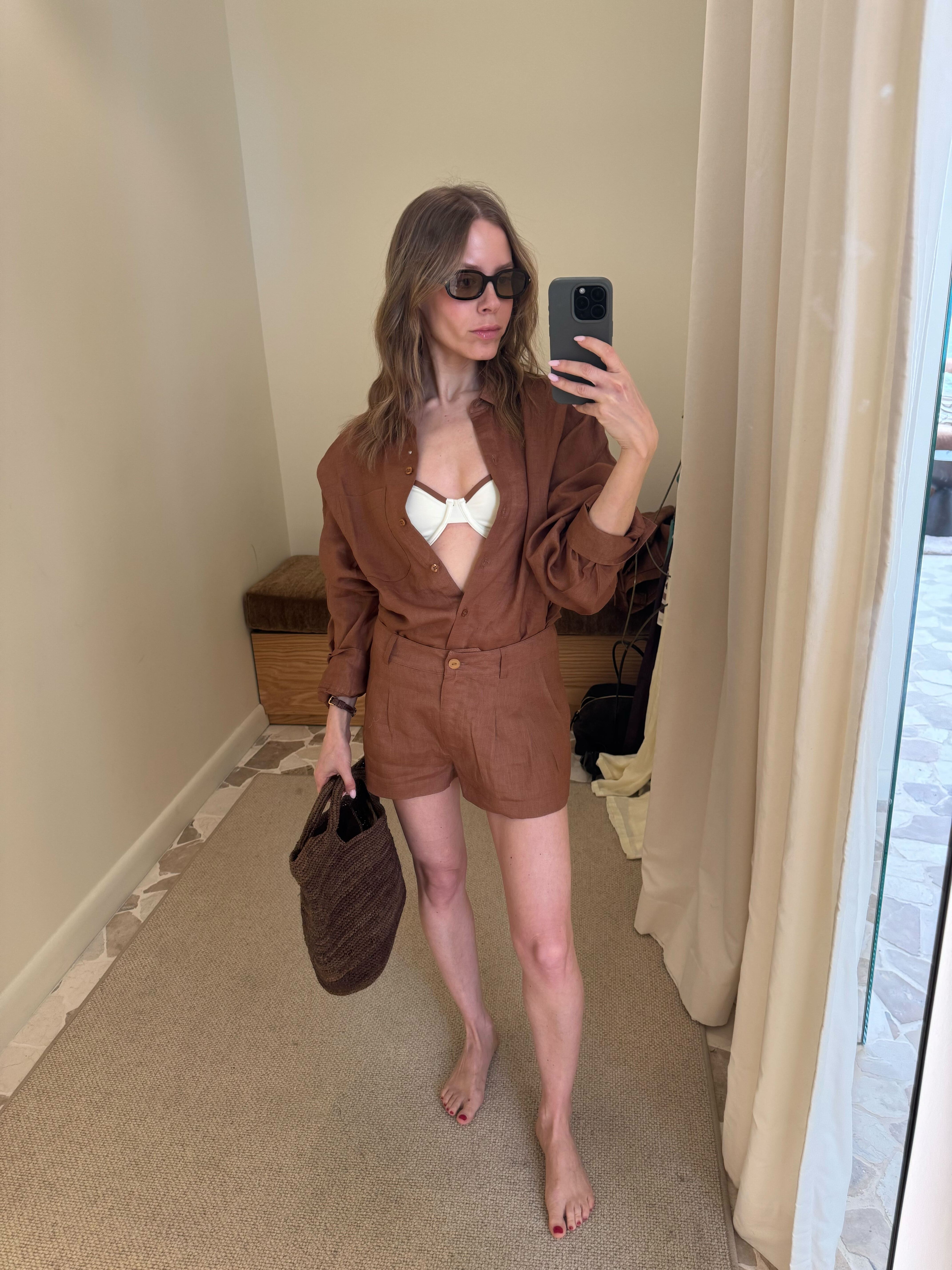 amggjsj7pdvr8ptwauo5c5 Nikki wears a brown button down shirt and shorts with a white bikini top and brown straw bag.